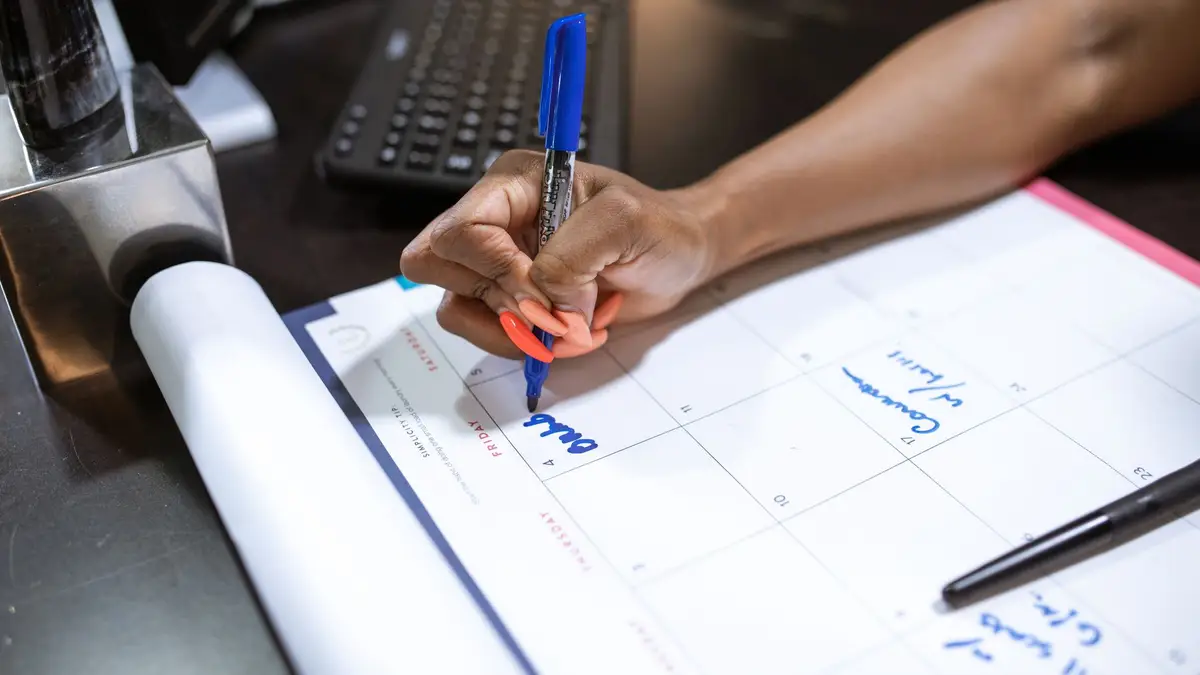 Calendar and planner on a desk with a marker