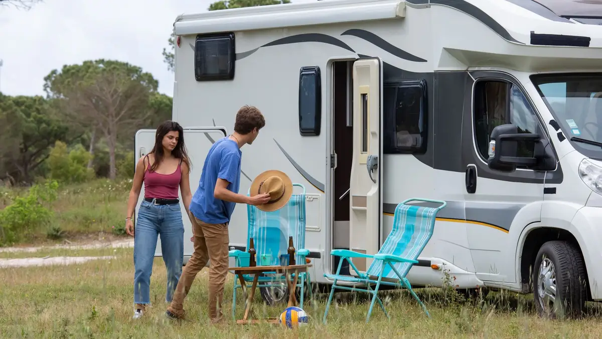 Couple with an RV parked on a road trip