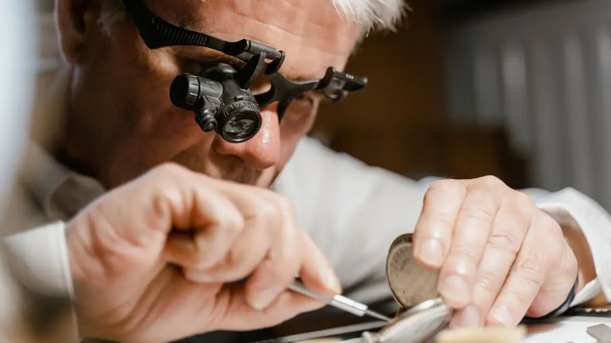 Older craftsman working at a bench with tools