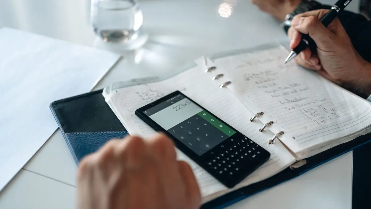 Calculator, notebook and pen on a desk for working out numbers