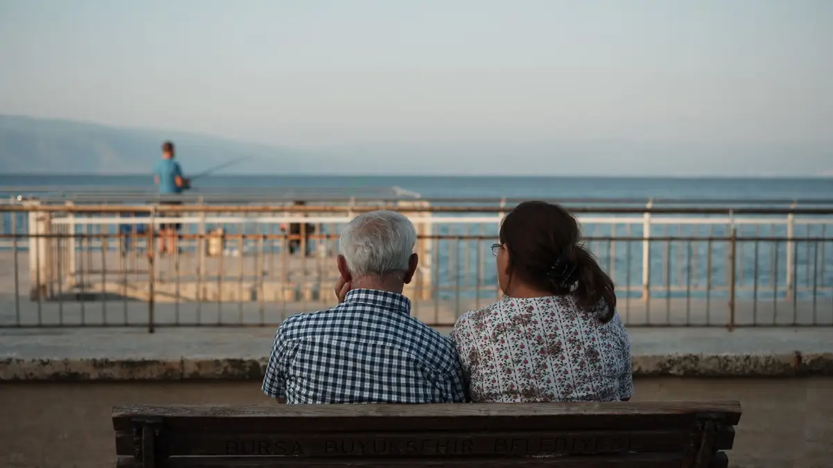 Senior couple watching the sunset from a bench