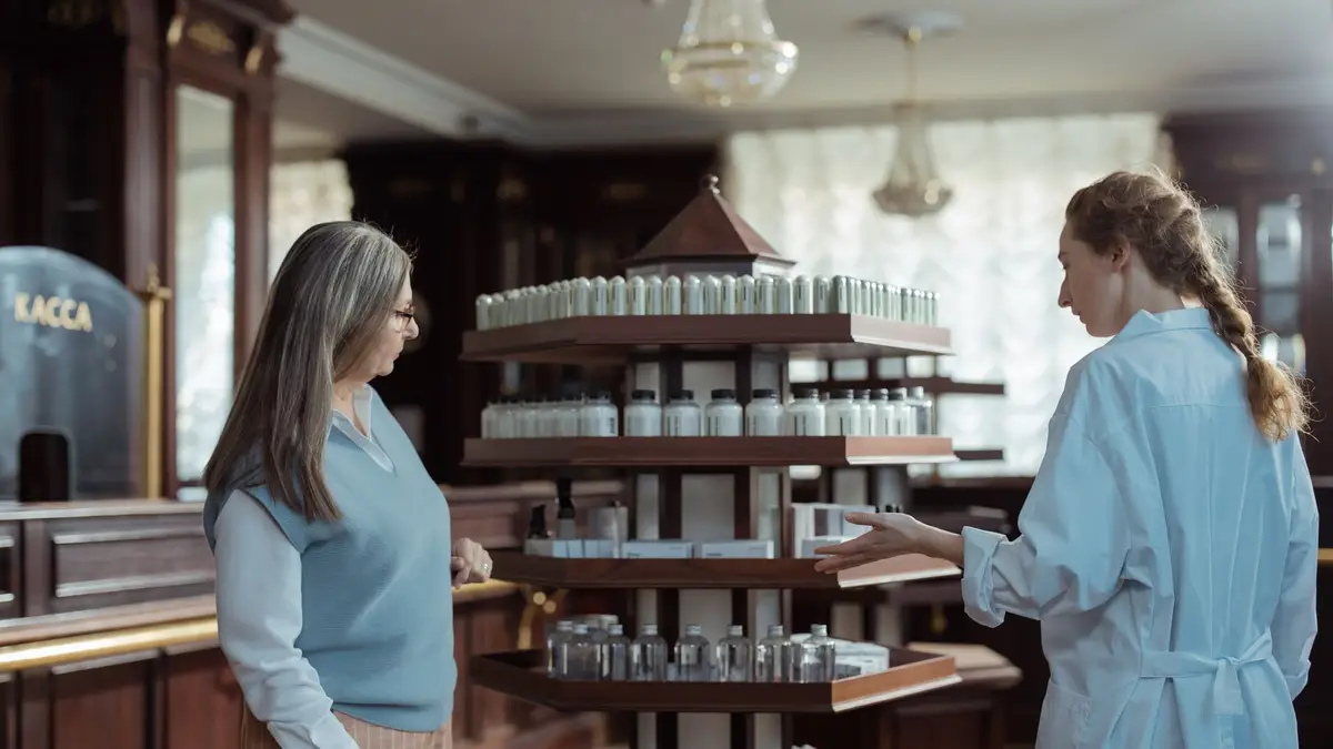 Pharmacist talking with an older customer at the counter