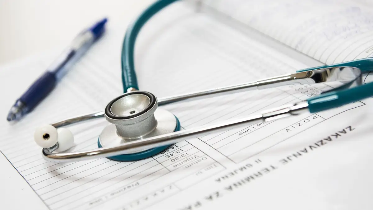 Medical bill and paperwork next to a stethoscope