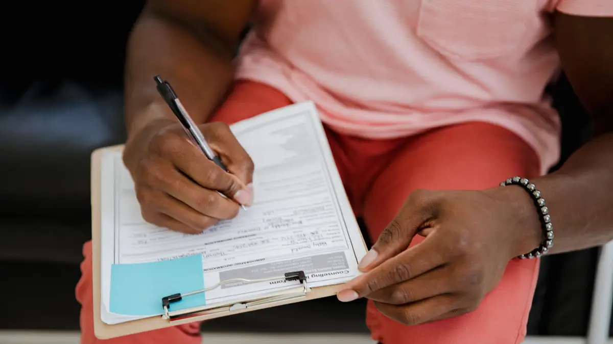 Senior man filling in a form on a clipboard