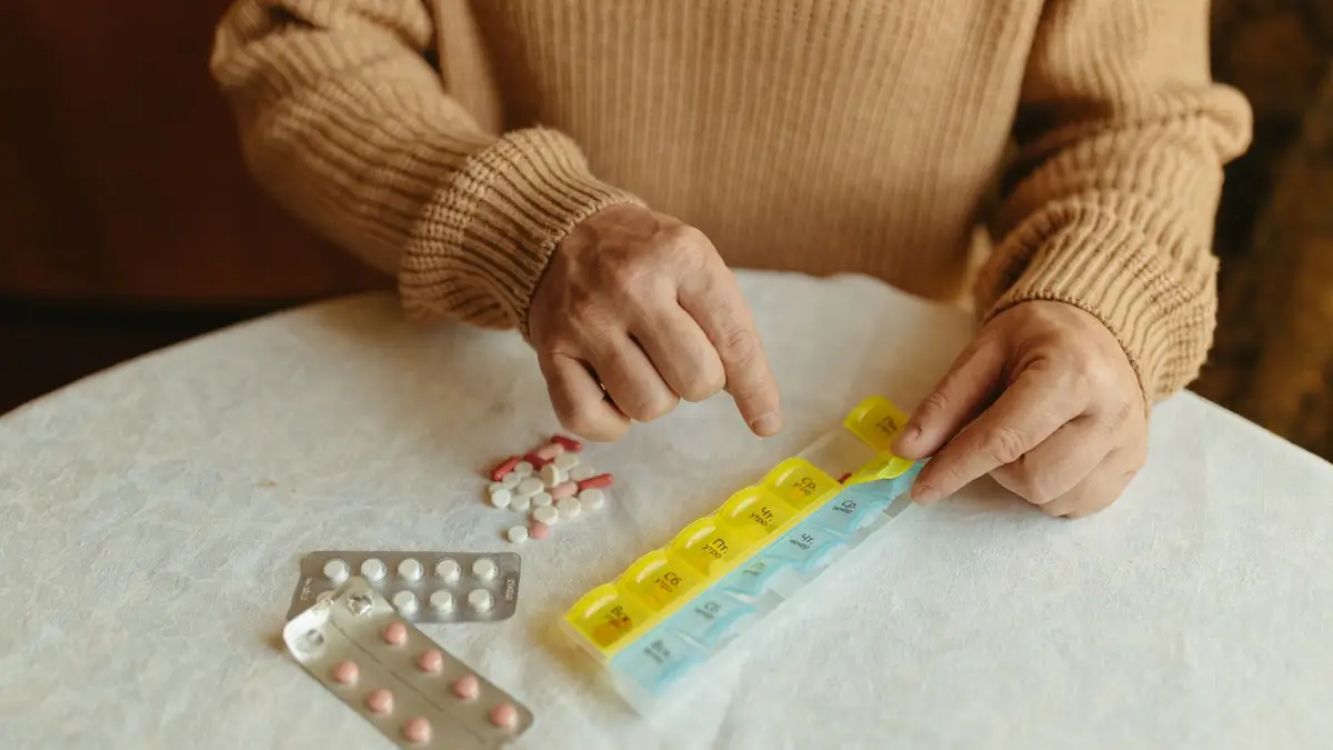 Older woman sorting pills into a weekly organizer