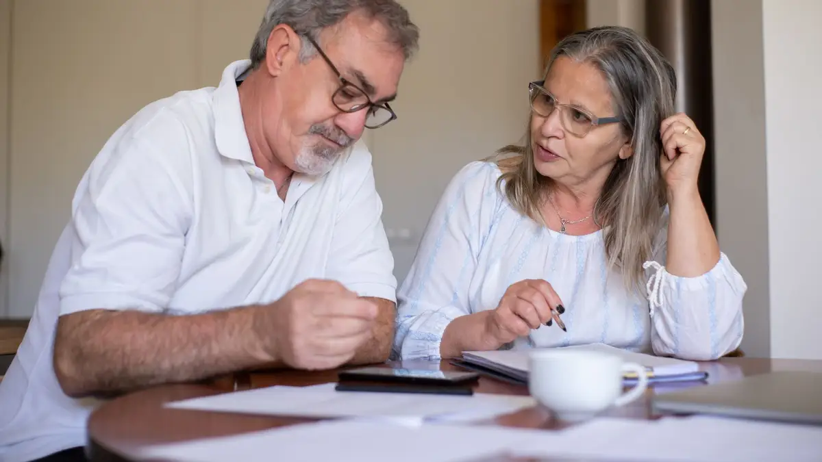Retired couple reviewing bills at the kitchen table