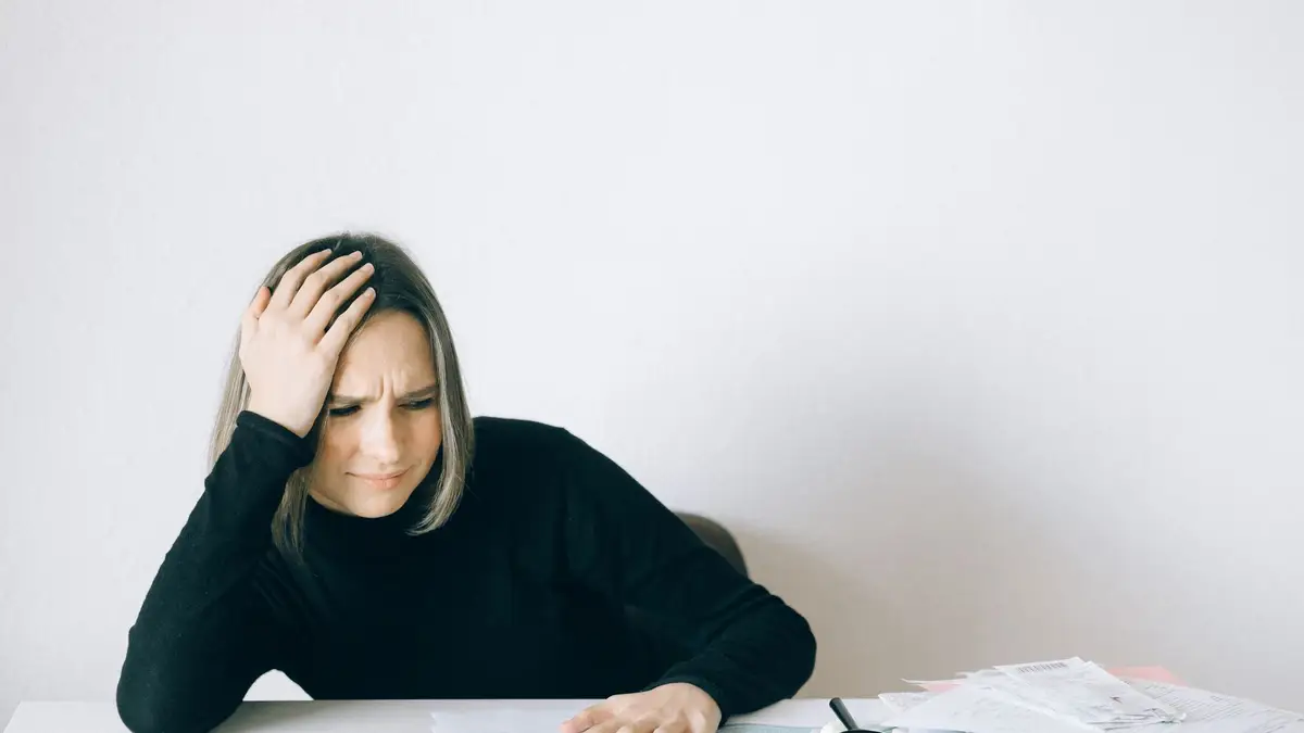 Older woman looking stressed while going through paperwork