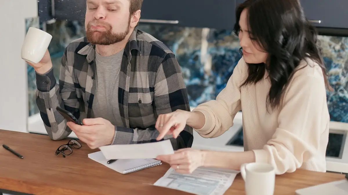 Older couple sitting at a kitchen table going through documents together