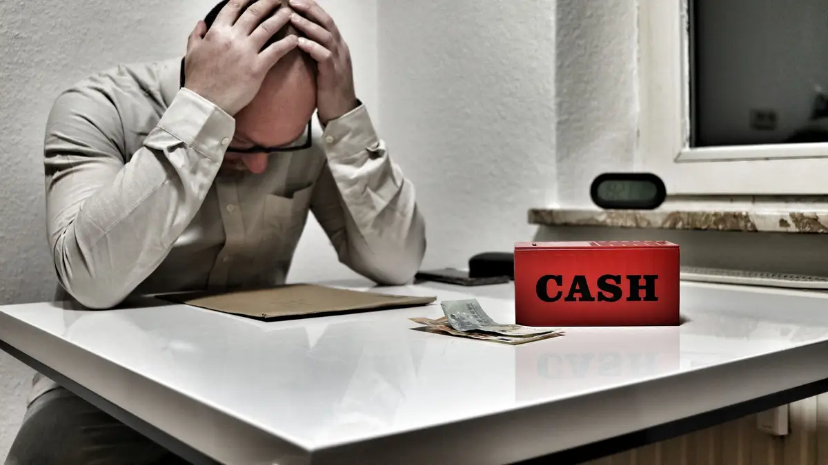 Older man looking worried over bills at a table