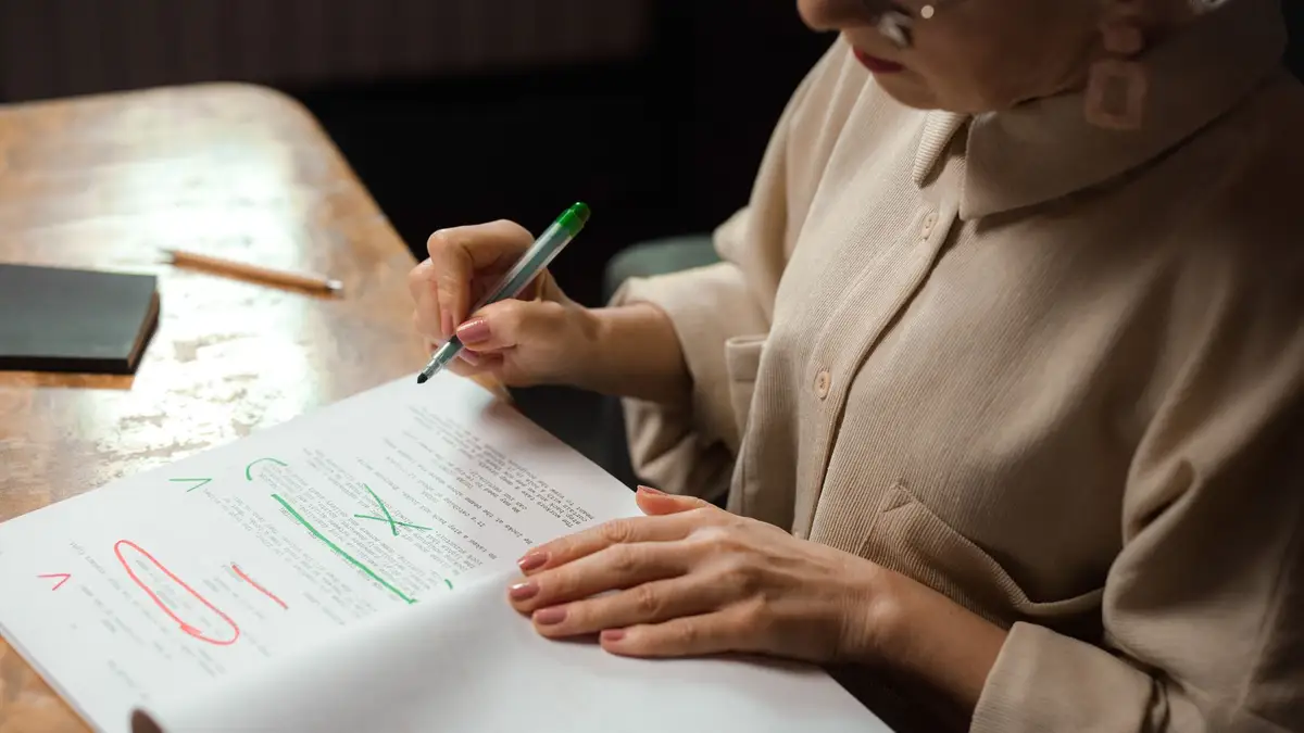 Elderly woman writing a check at her table
